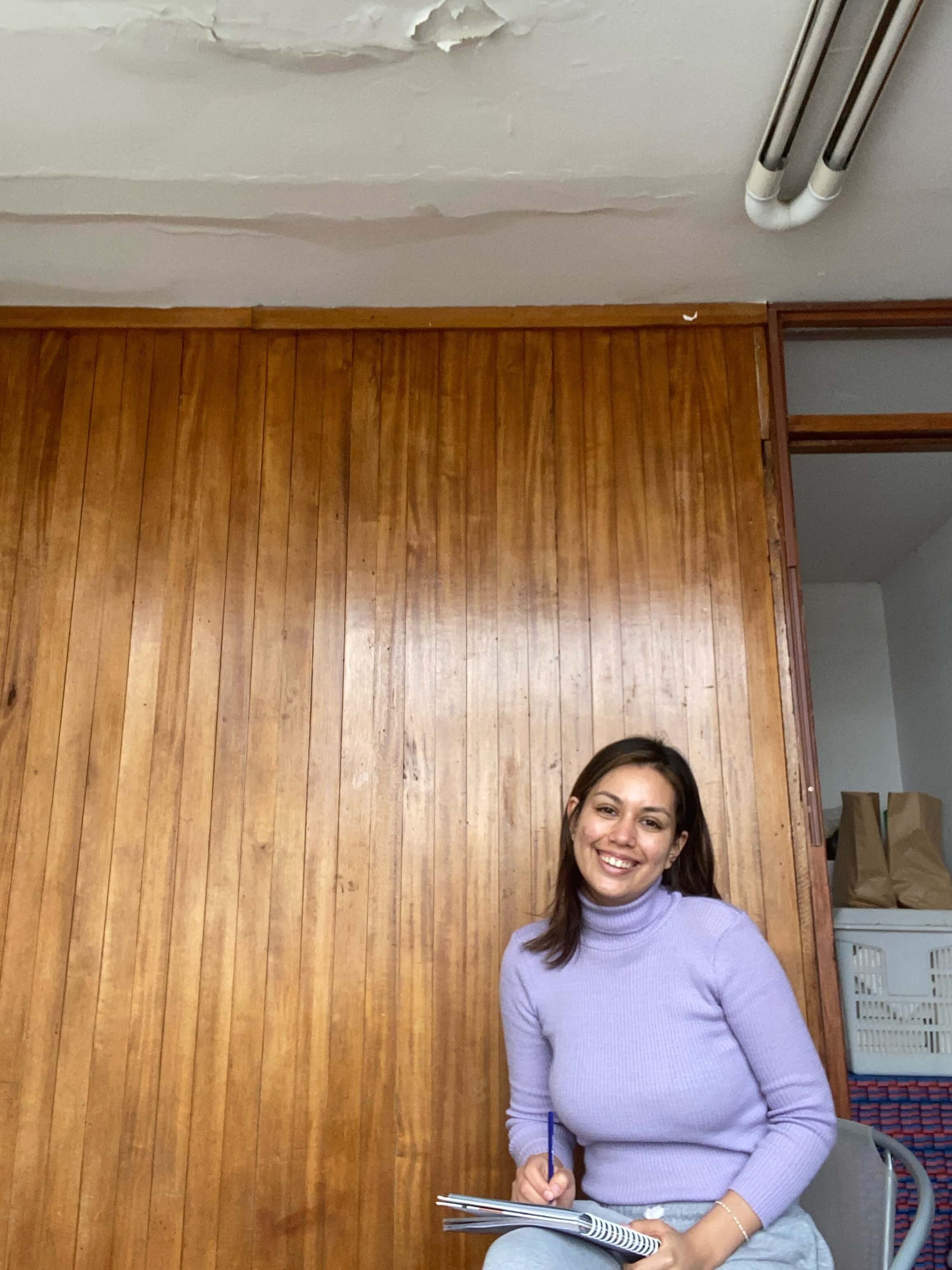 The therapist seated against a wood-panelled wall during a session