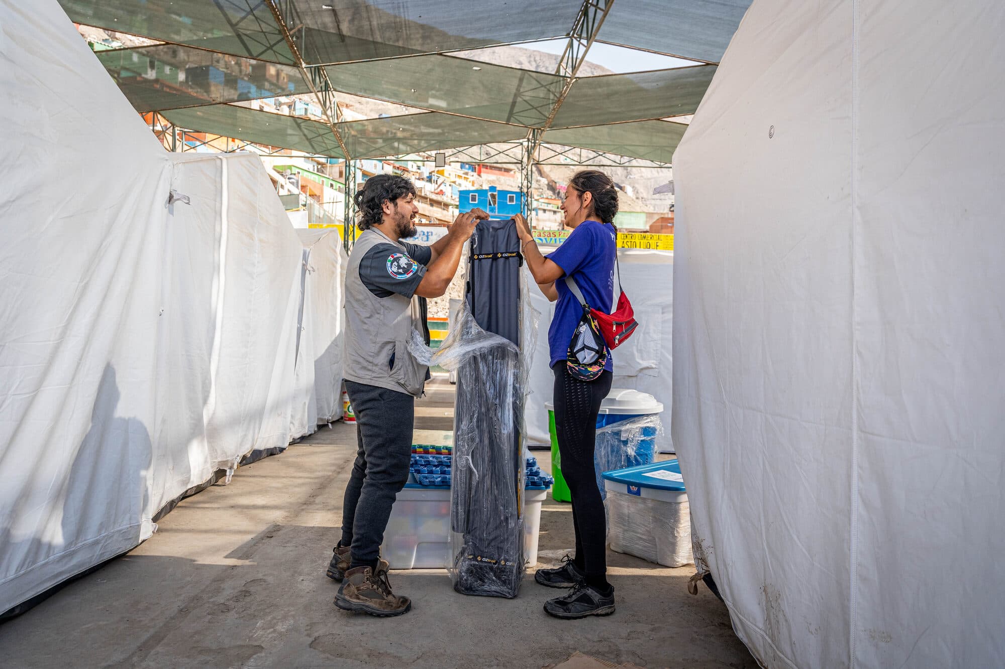 CADENA volunteers setting up a water filtration unit between relief tents