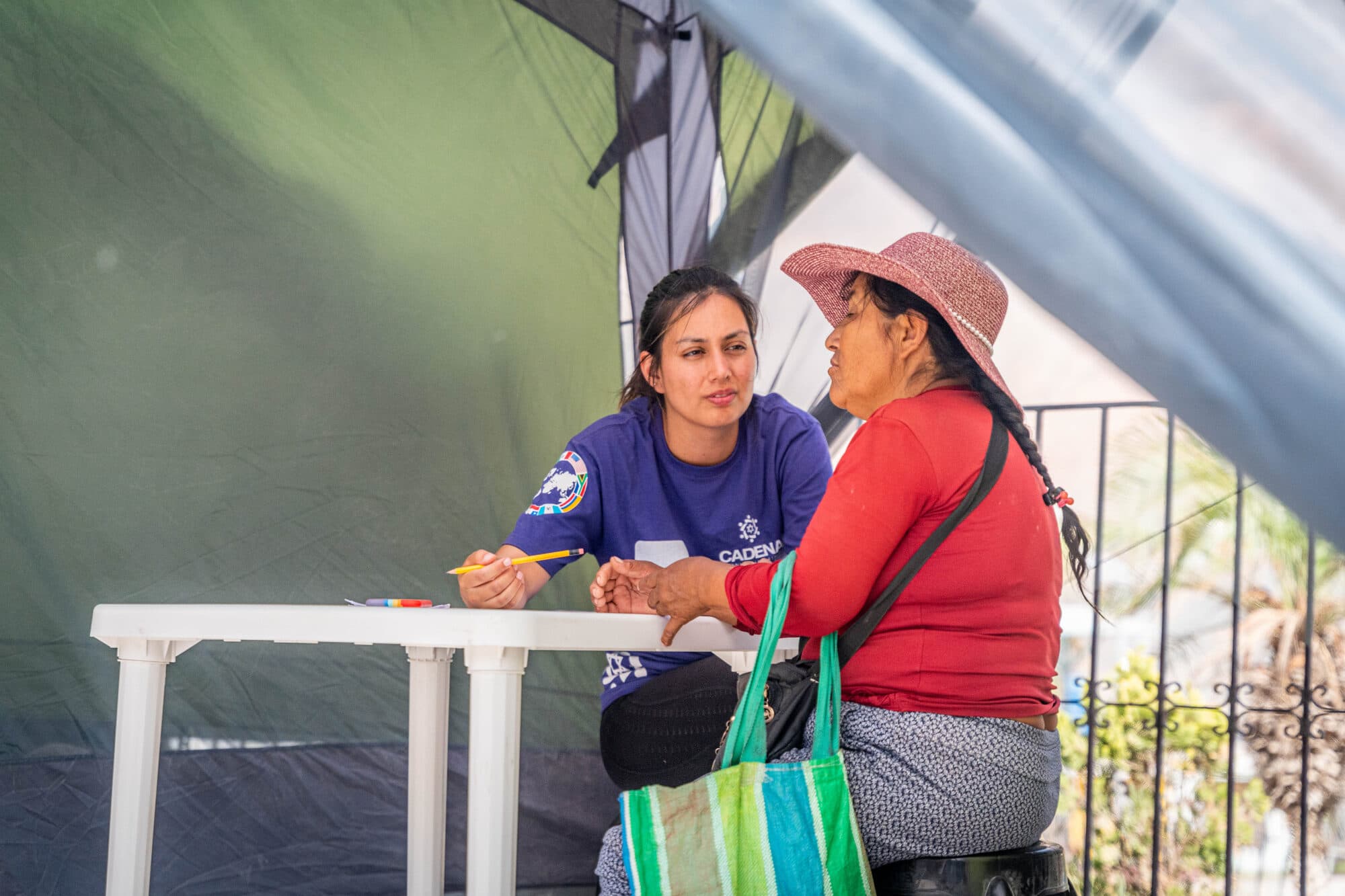 A CADENA psychologist providing one-on-one support to a community member at a table