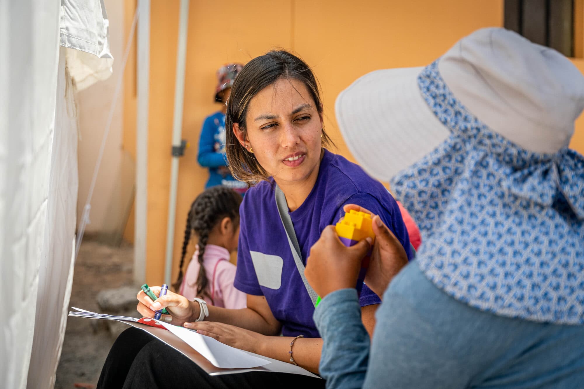 A CADENA psychologist taking notes during a play-based session with a child