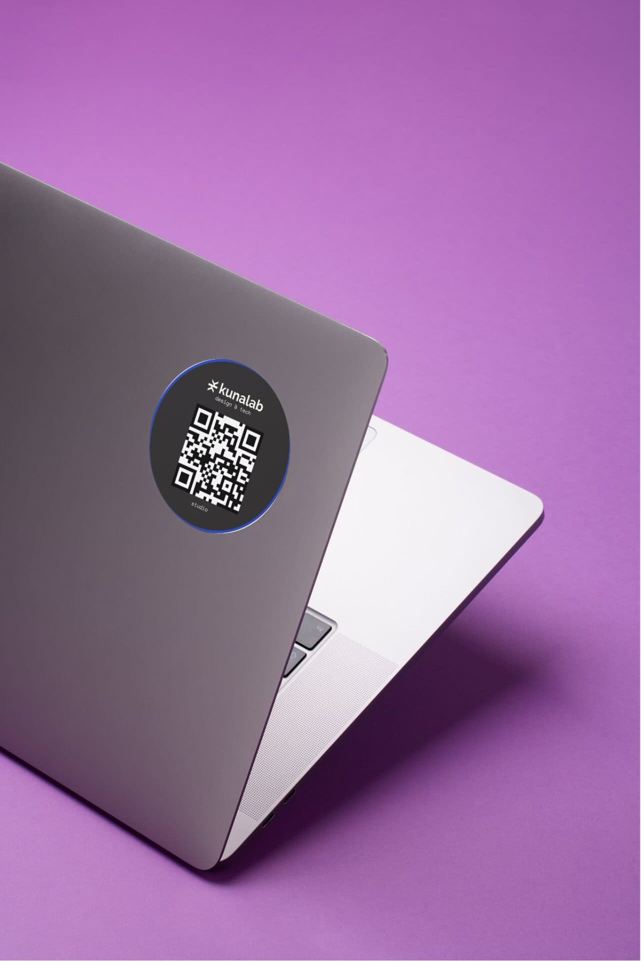 A laptop with a Kunalab QR-code sticker on a purple background